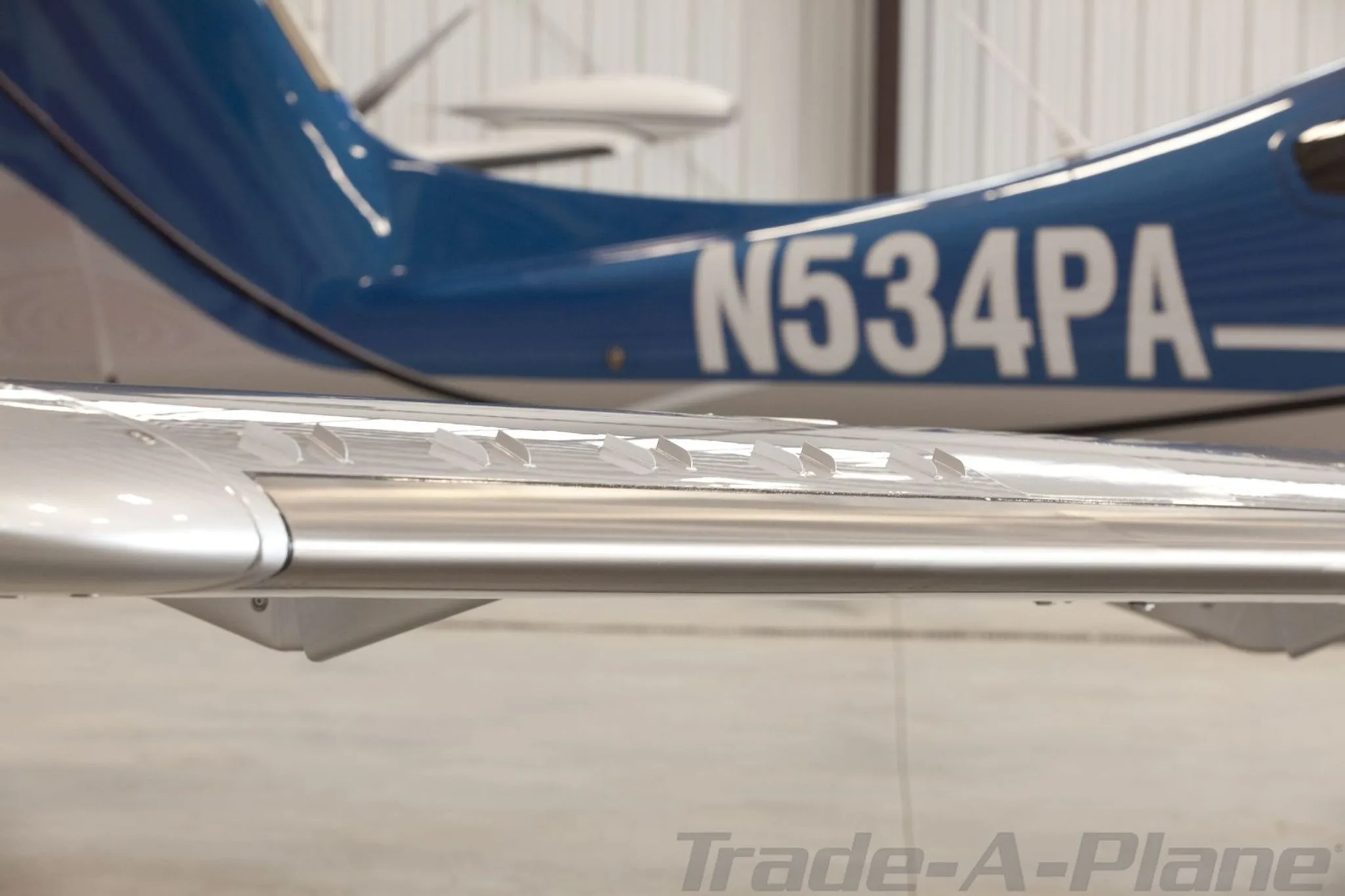 A close-up of the wing and tail section of the blue and silver Diamond DA62, showing the registration N534PA.