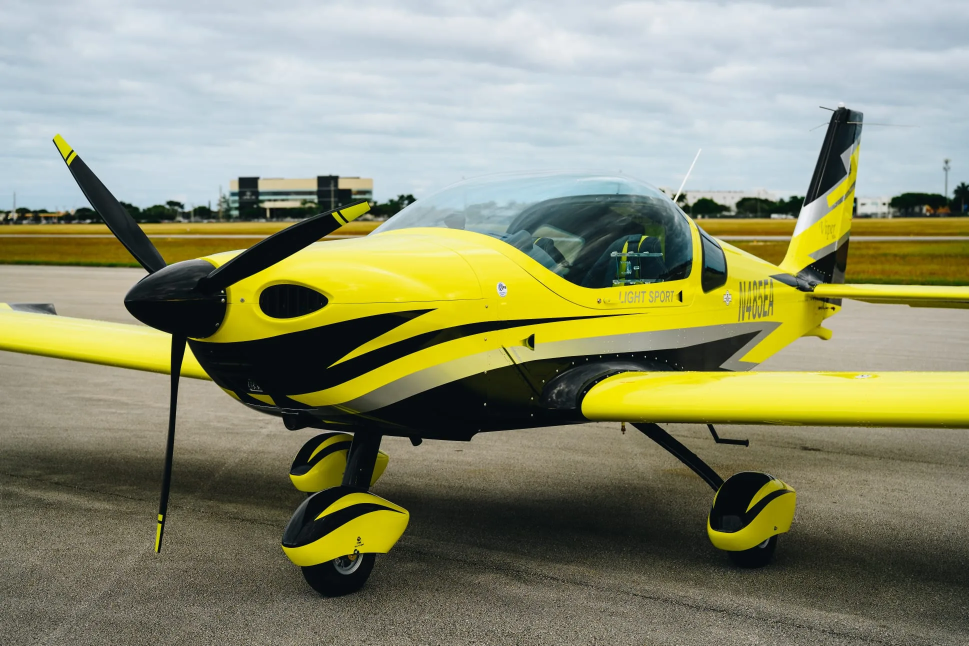 A yellow and black Viper SD4 light sport aircraft with registration N485EA parked on an airfield.