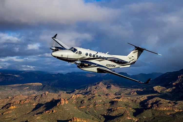 N365WM King Air flying over a mountainous landscape.