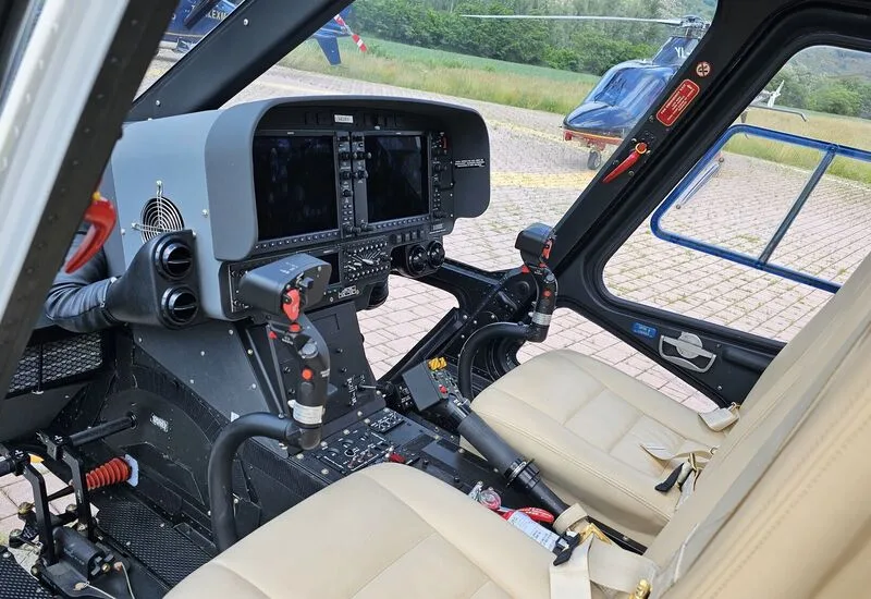 Cockpit view of the AgustaWestland AW109 helicopter instrument panel and seats.