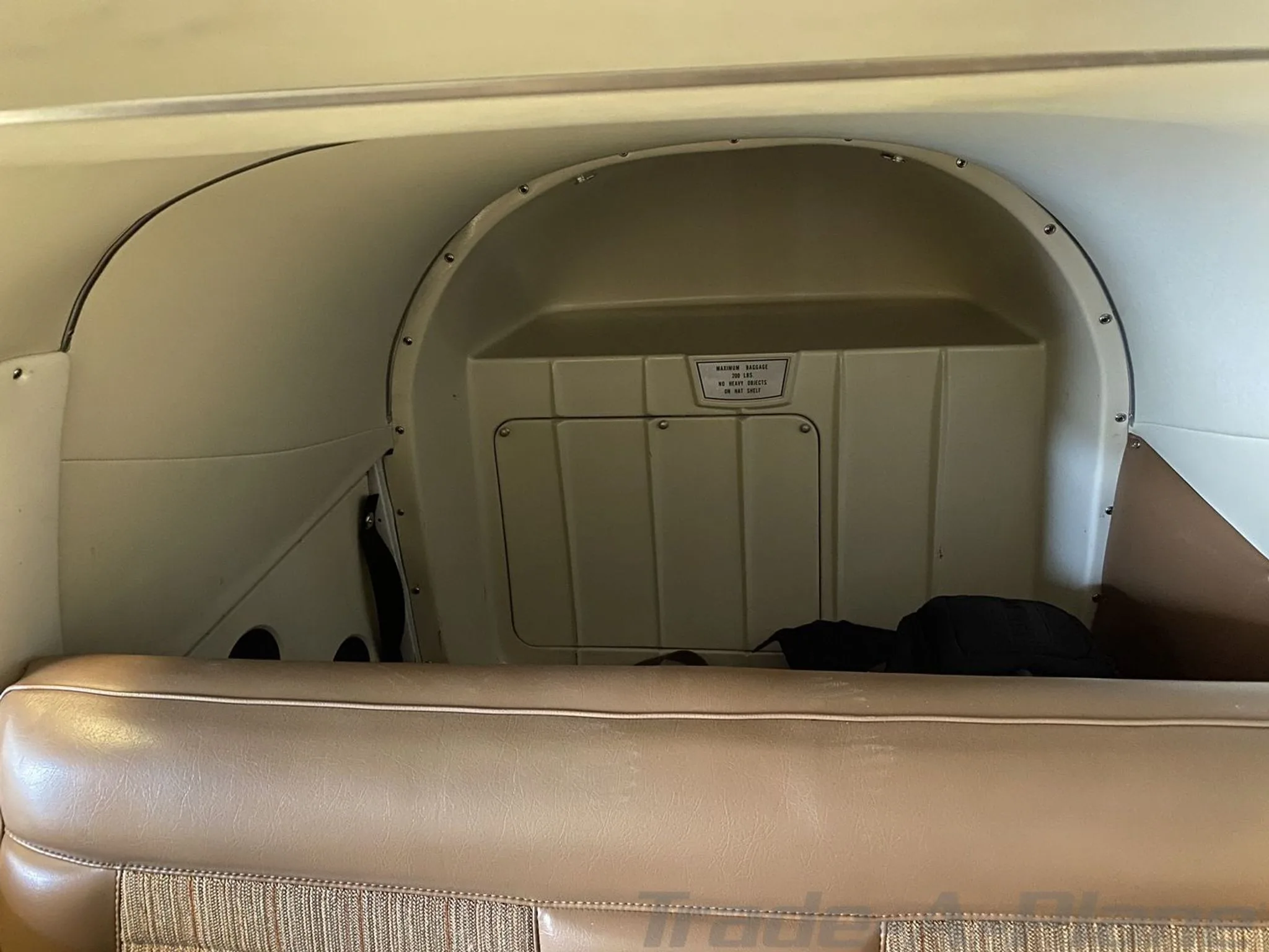 The rear baggage compartment and cabin wall of the aircraft interior.
