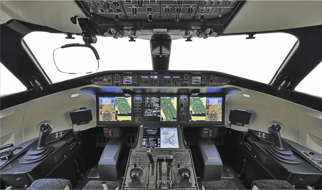 The modern cockpit of a business jet, featuring multiple large digital displays and advanced controls.