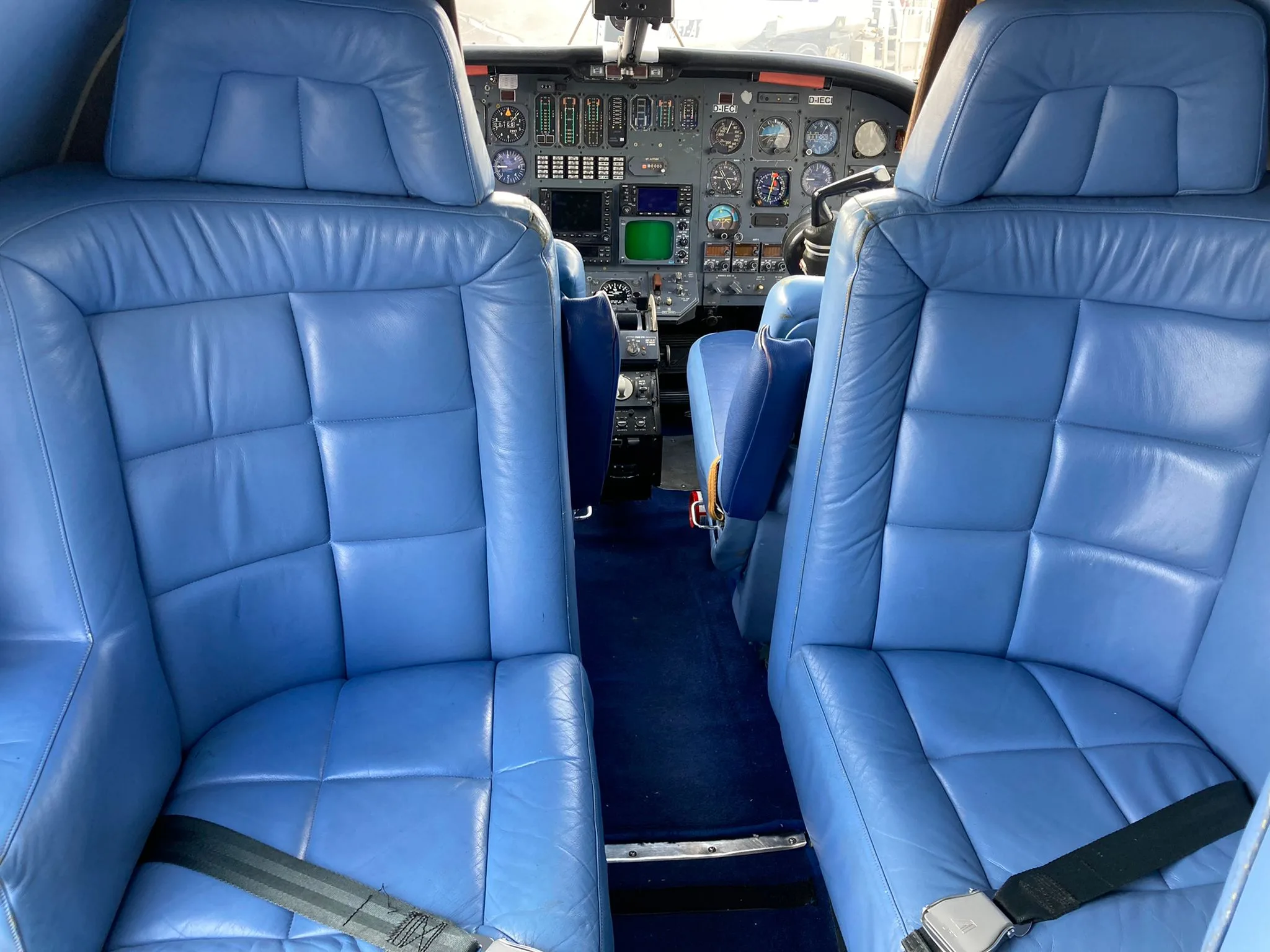 View of the cockpit and blue leather seats of the aircraft.