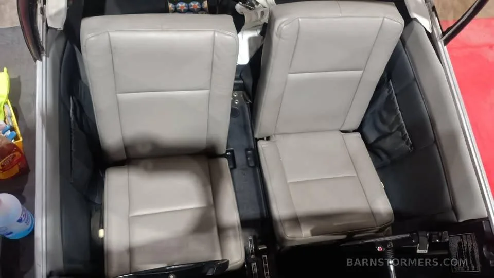 The light gray leather seats in the interior cabin of an aircraft.