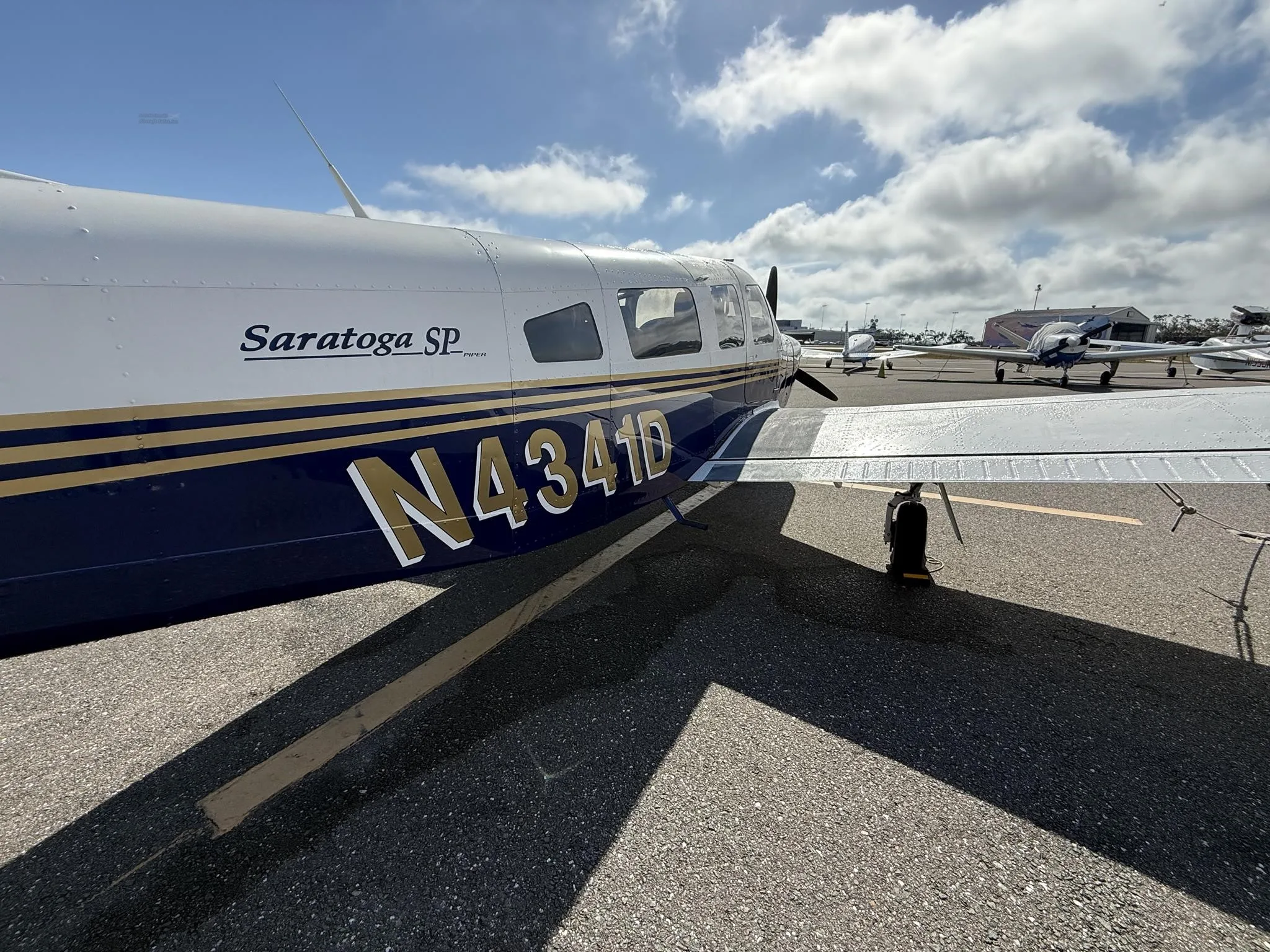 A close-up side view of the Piper Saratoga SP (N4341D) showing its blue and white paint scheme and registration.