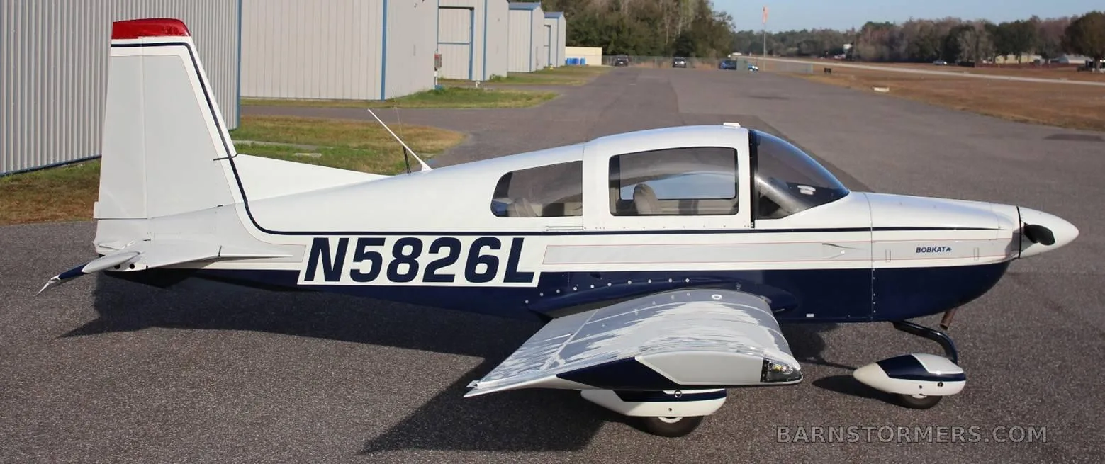 A white and blue Bobcat aircraft (N5826L) parked on an airfield, viewed from the rear left side.