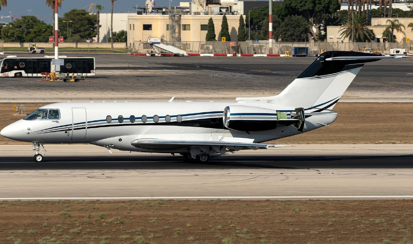 A white and black business jet is shown on the runway.