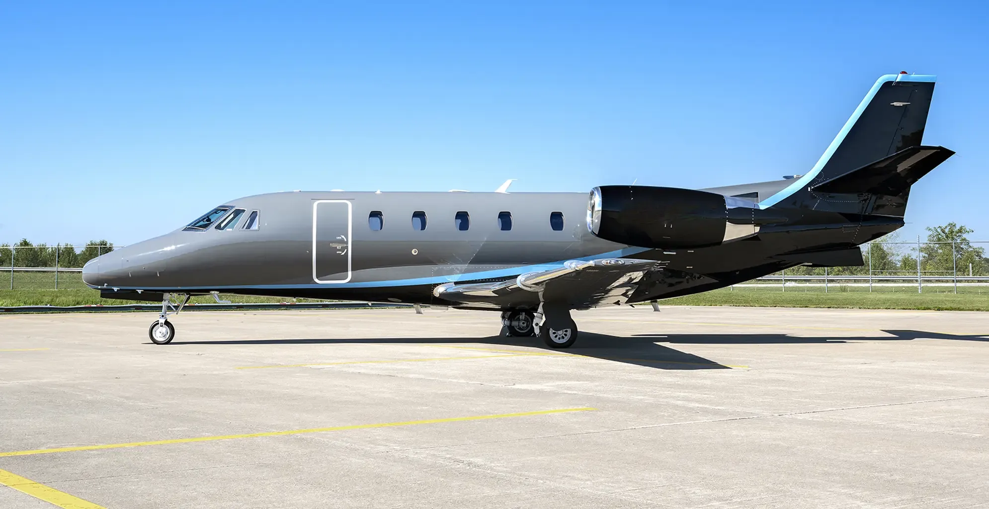 Side view of a gray and black Cessna Citation Latitude on the tarmac.