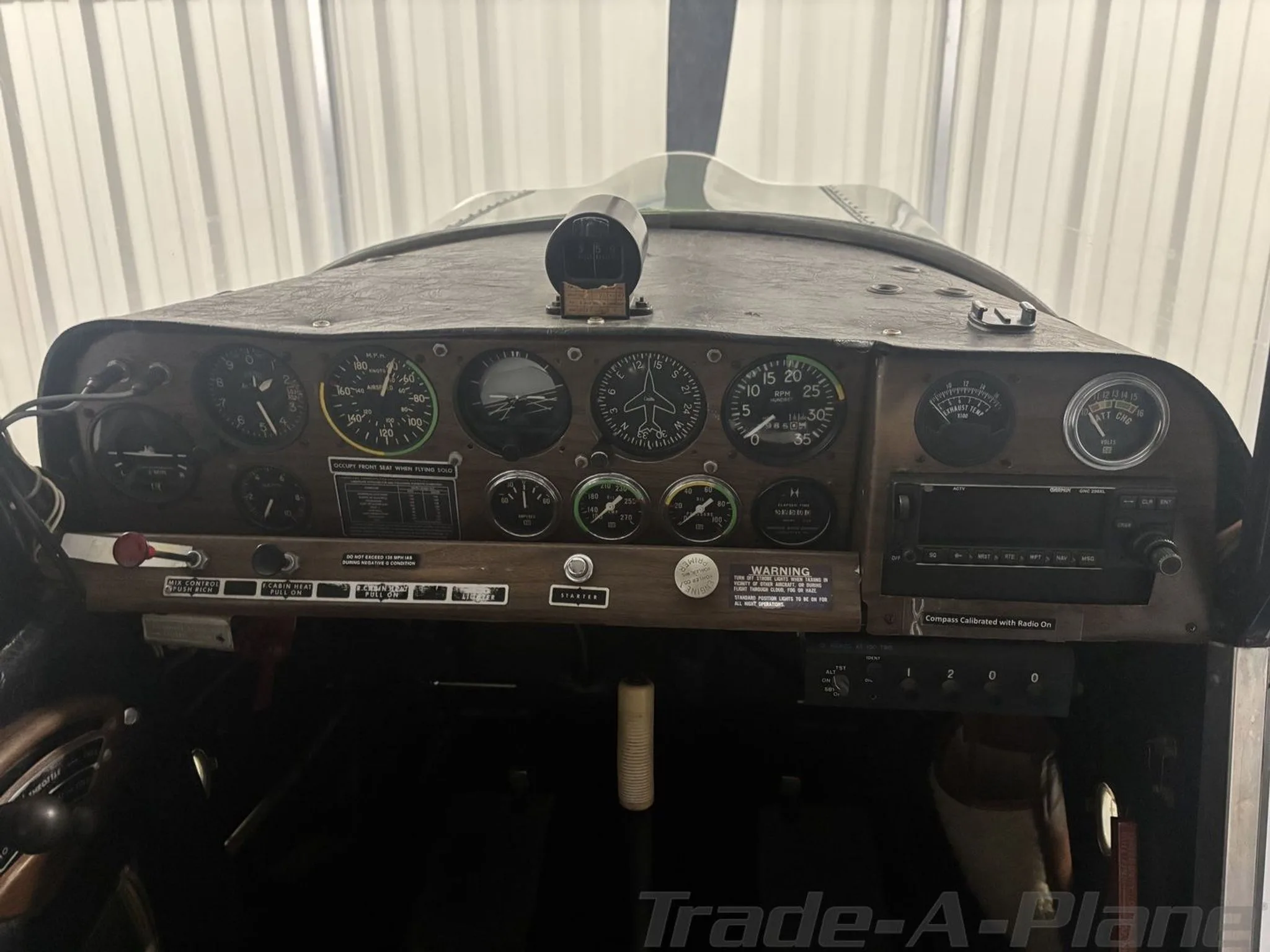 The instrument panel of the aircraft, featuring various gauges, switches, and a radio.