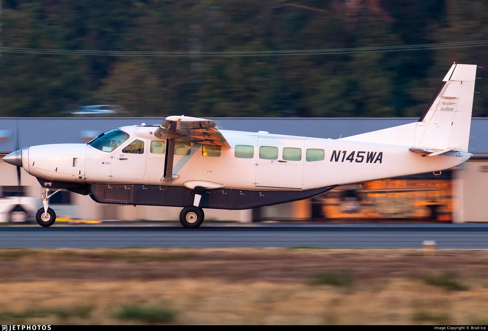 A Cessna 208 Caravan with the tail number N145WA is parked on the tarmac.