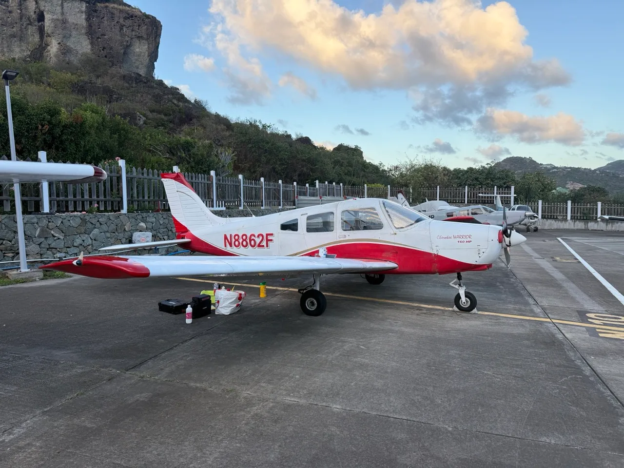 A white and red Piper Cherokee Warrior 160 HP aircraft (N8862F) parked on an airfield, viewed from the front-right.