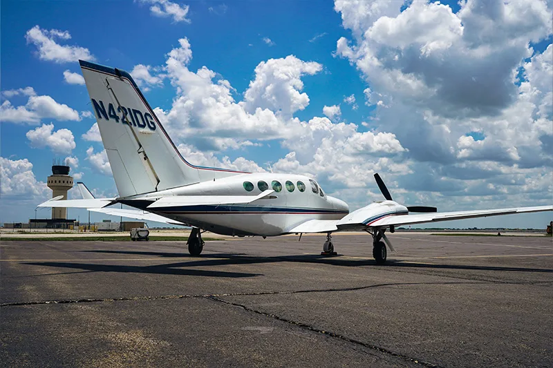 The tail of a Cessna 421 Golden Eagle aircraft with registration N421DG is visible on the tarmac.