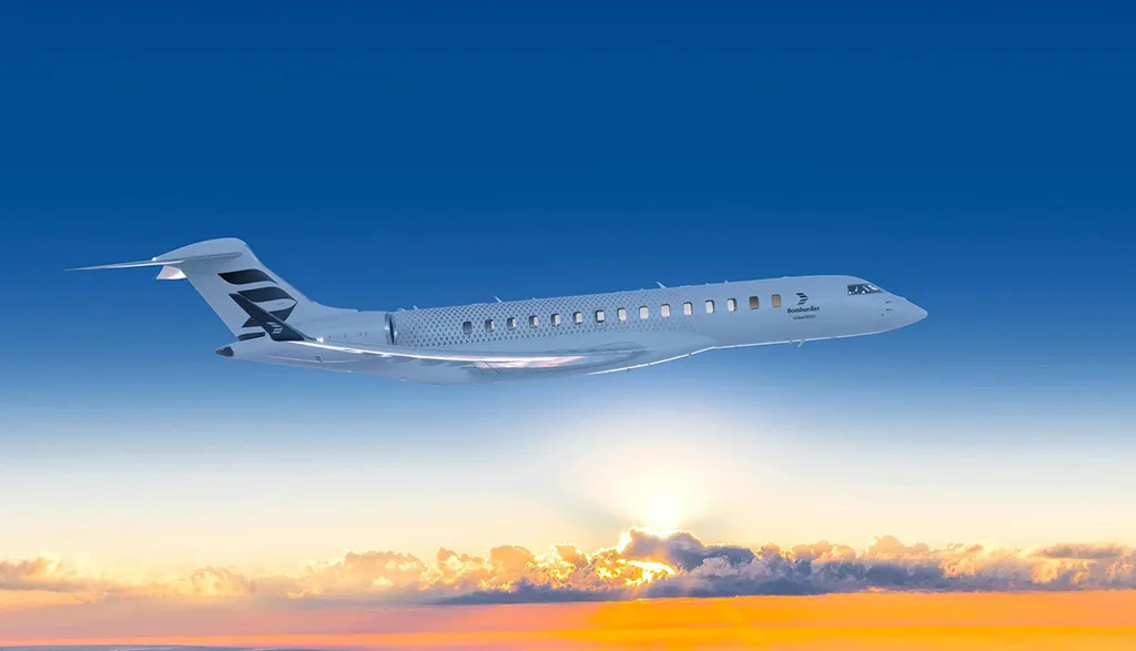 A white Bombardier Global 6000 business jet flying at sunset over clouds.