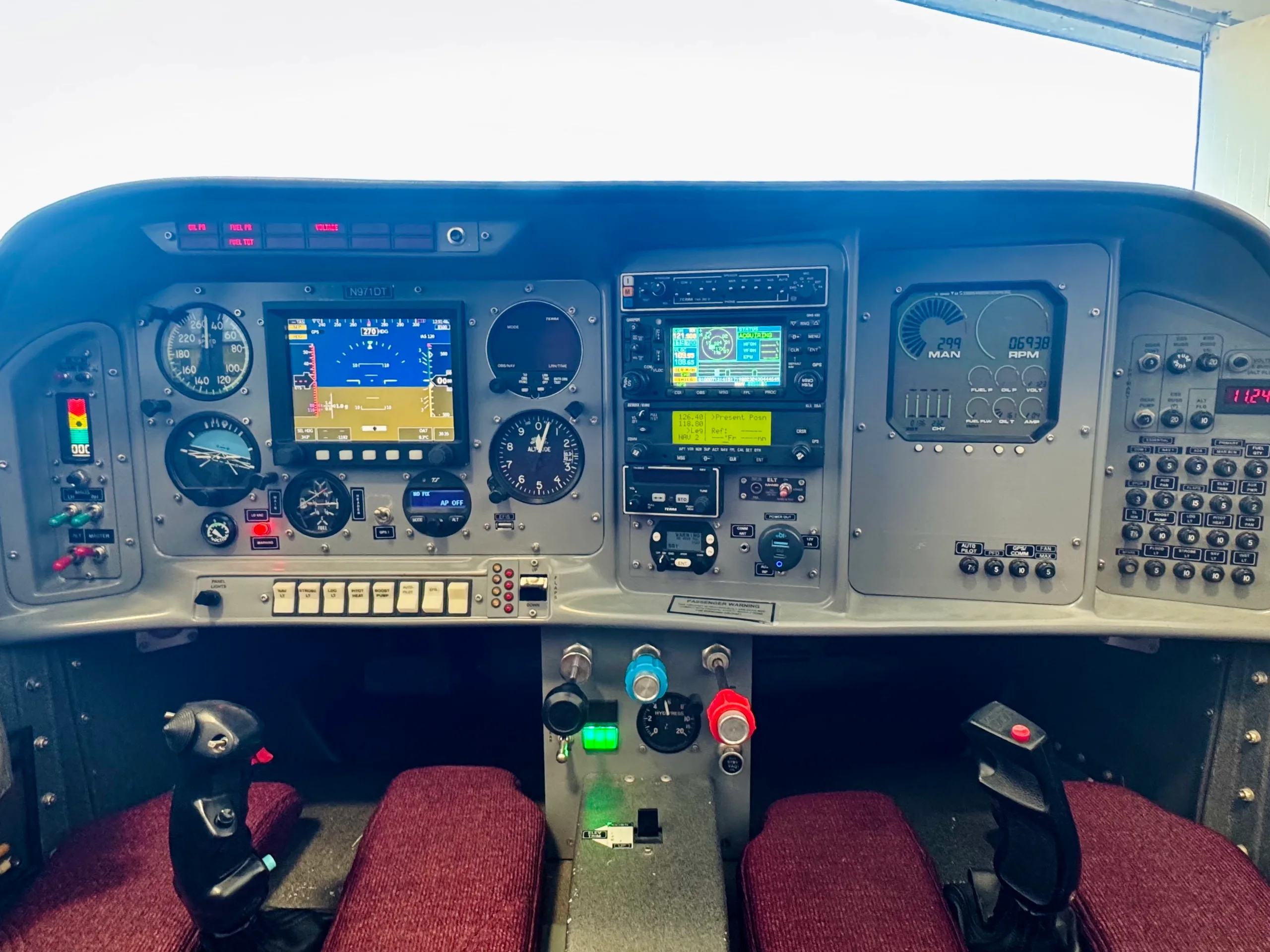 A detailed view of the aircraft's instrument panel, featuring multiple digital displays, analog gauges, and various controls.