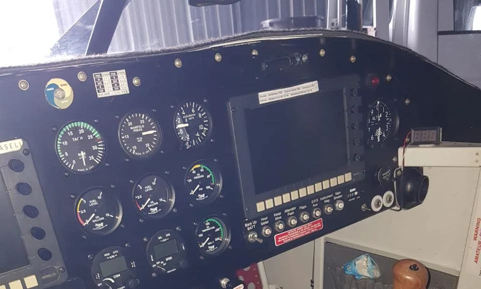 A close-up view of an aircraft cockpit instrument panel with analog gauges and a digital display.