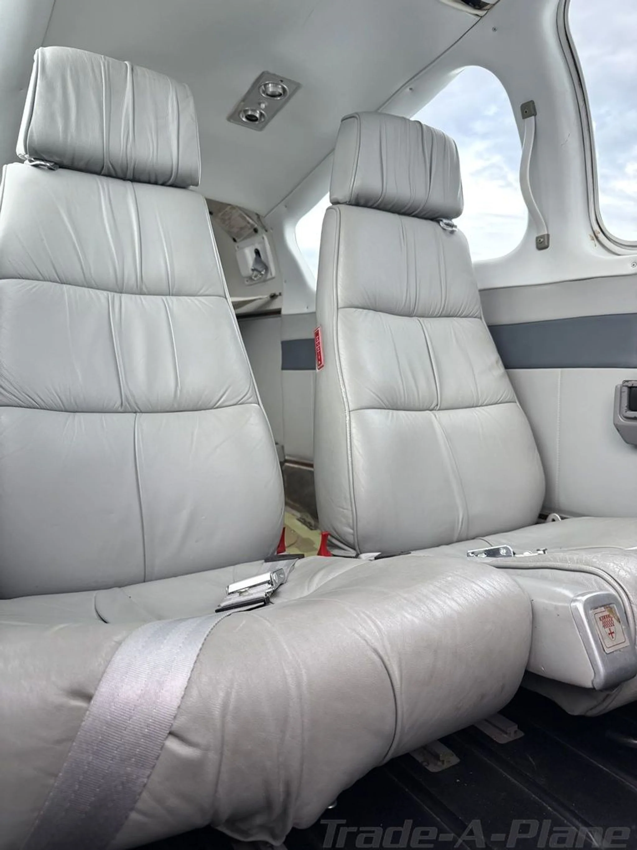 The grey leather passenger seats in the cabin of a small aircraft.