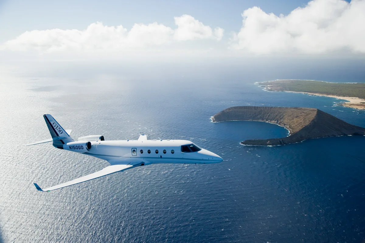 A G150 aircraft flying over the ocean.