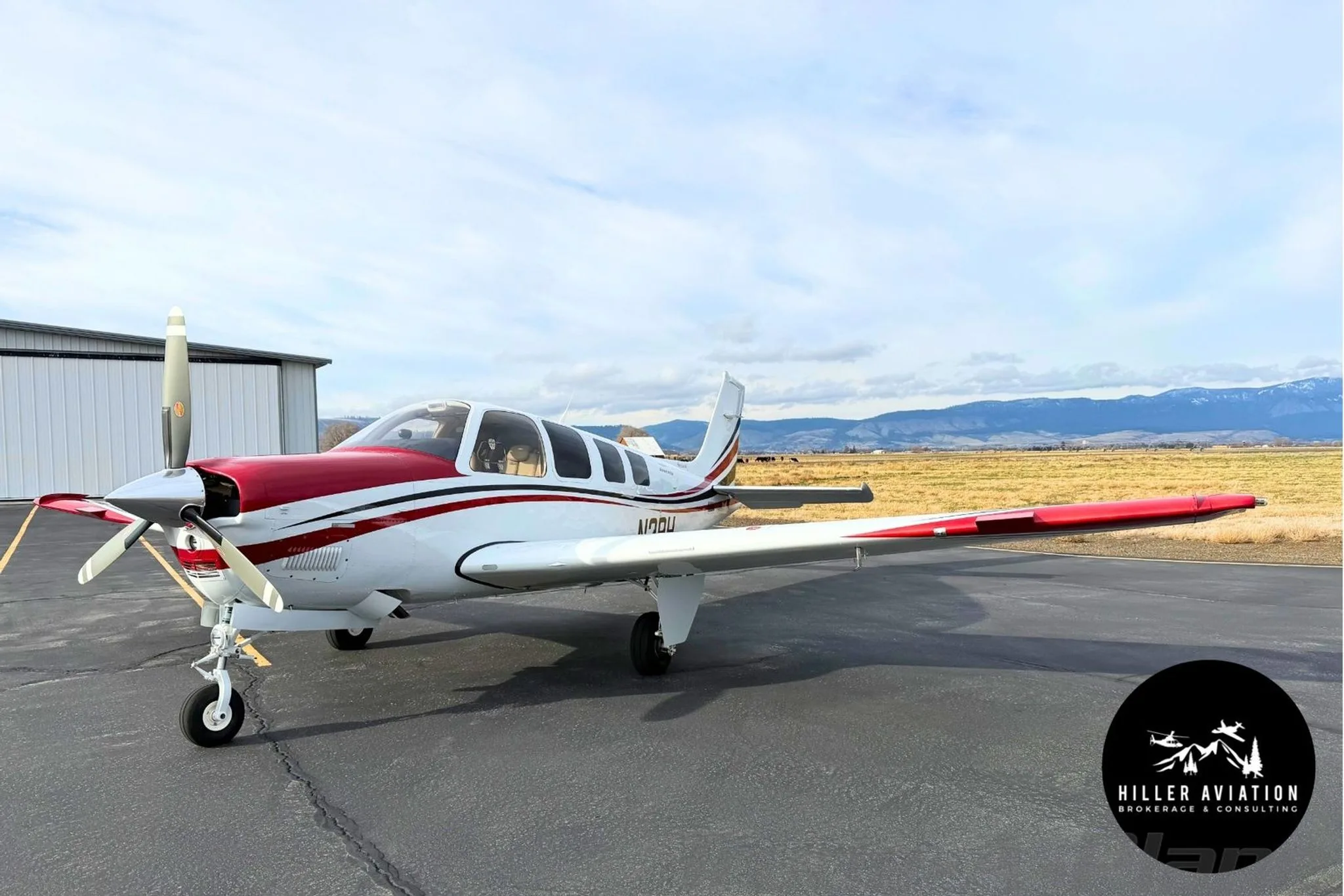 Front three-quarter view of a white and red Beechcraft Bonanza G36 (N2BH) on an airfield.