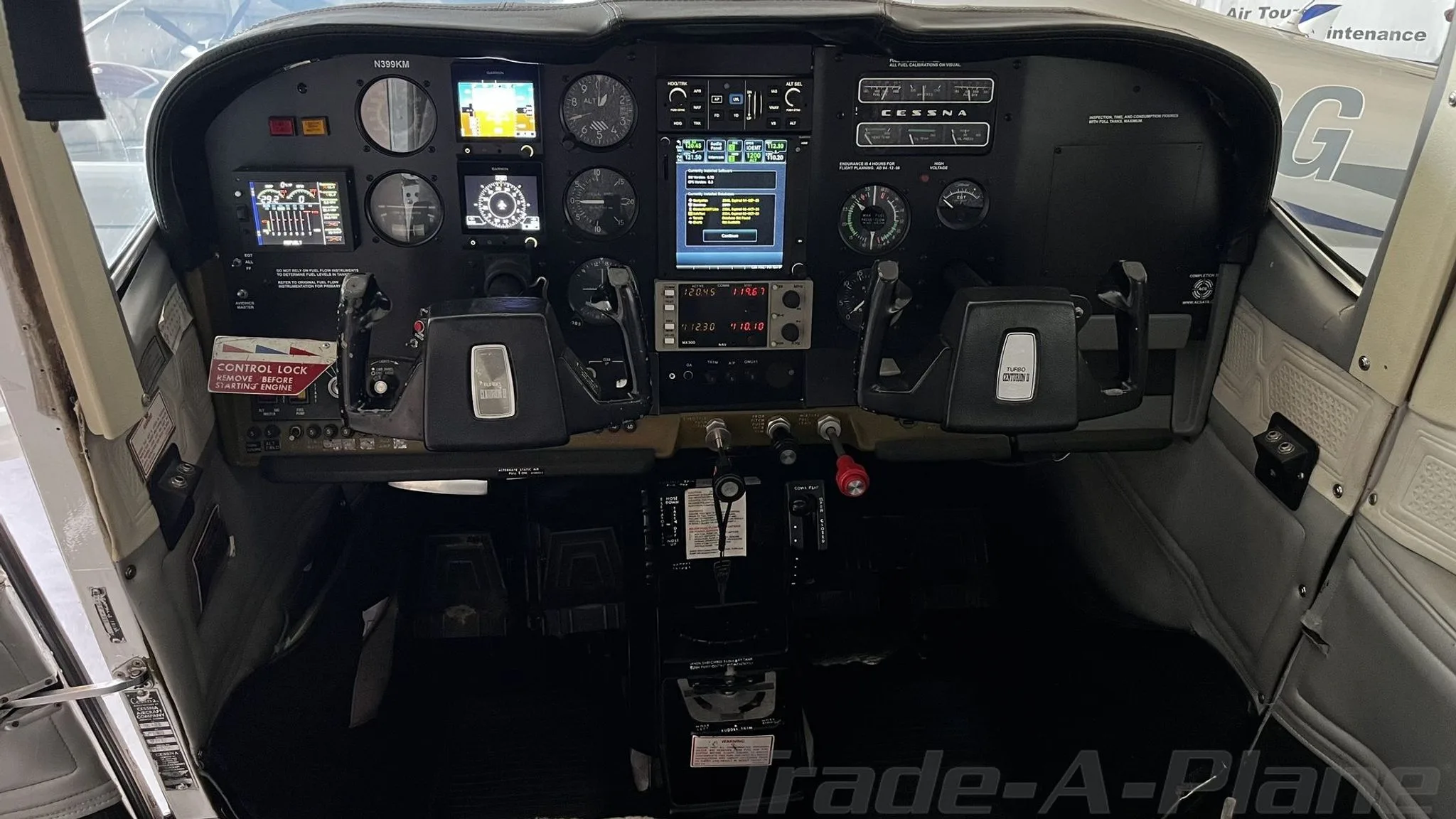The cockpit of a Cessna 210 Centurion, showing the instrument panel with various gauges and screens.