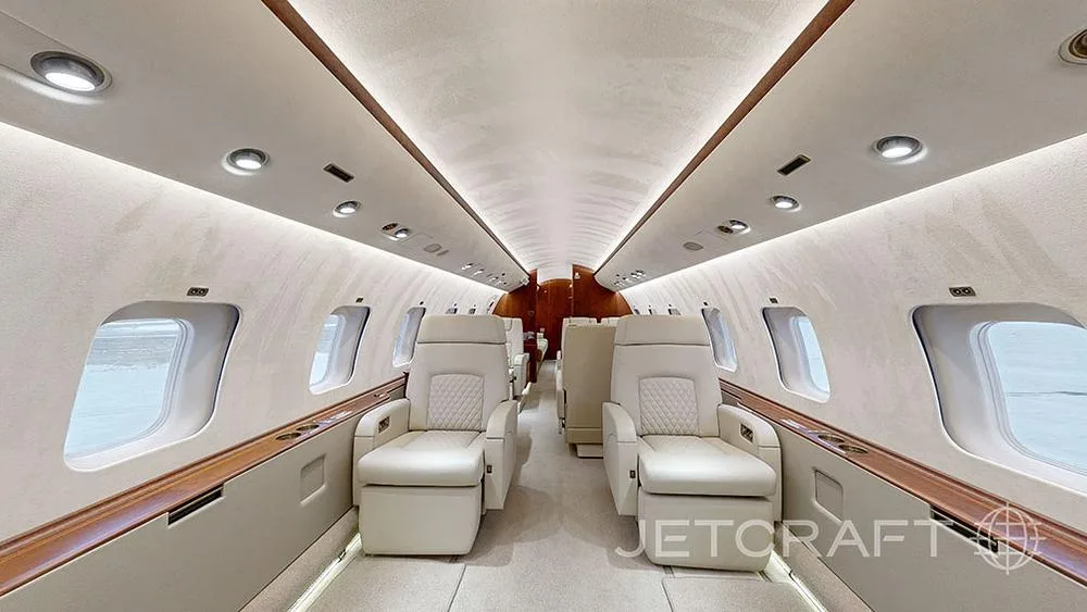 The luxurious interior cabin features two rows of cream-colored quilted leather seats facing each other.