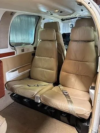 The tan leather passenger seats in the cabin of a Beechcraft Baron 58.