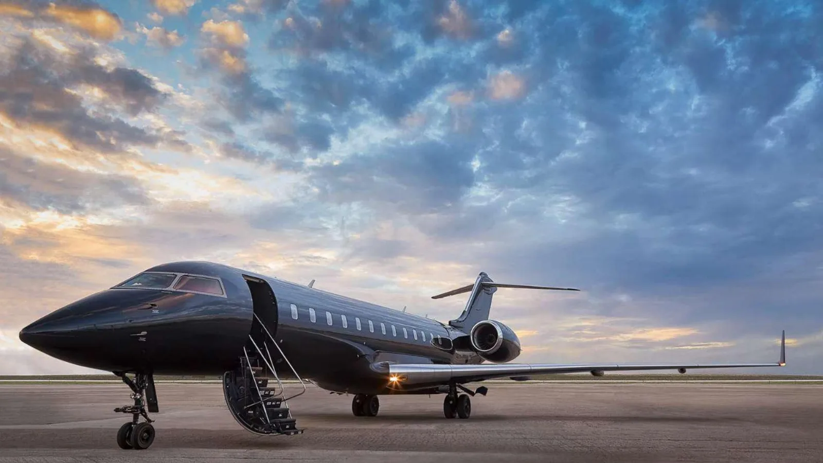 A luxurious private jet interior with white quilted leather seats and a table set with food and drinks.