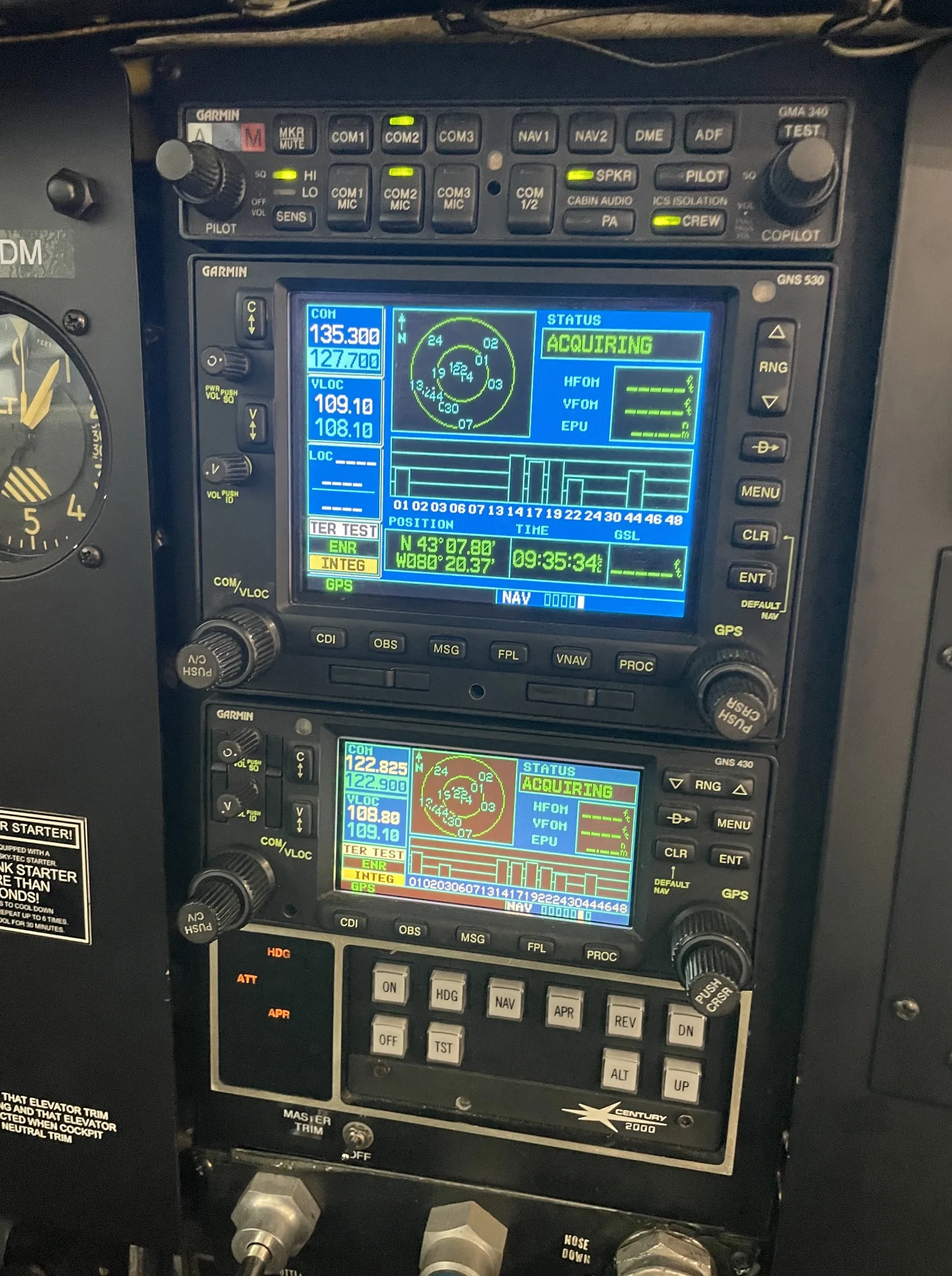 A close-up of an aircraft's avionics stack, featuring two Garmin GNS units and other controls.