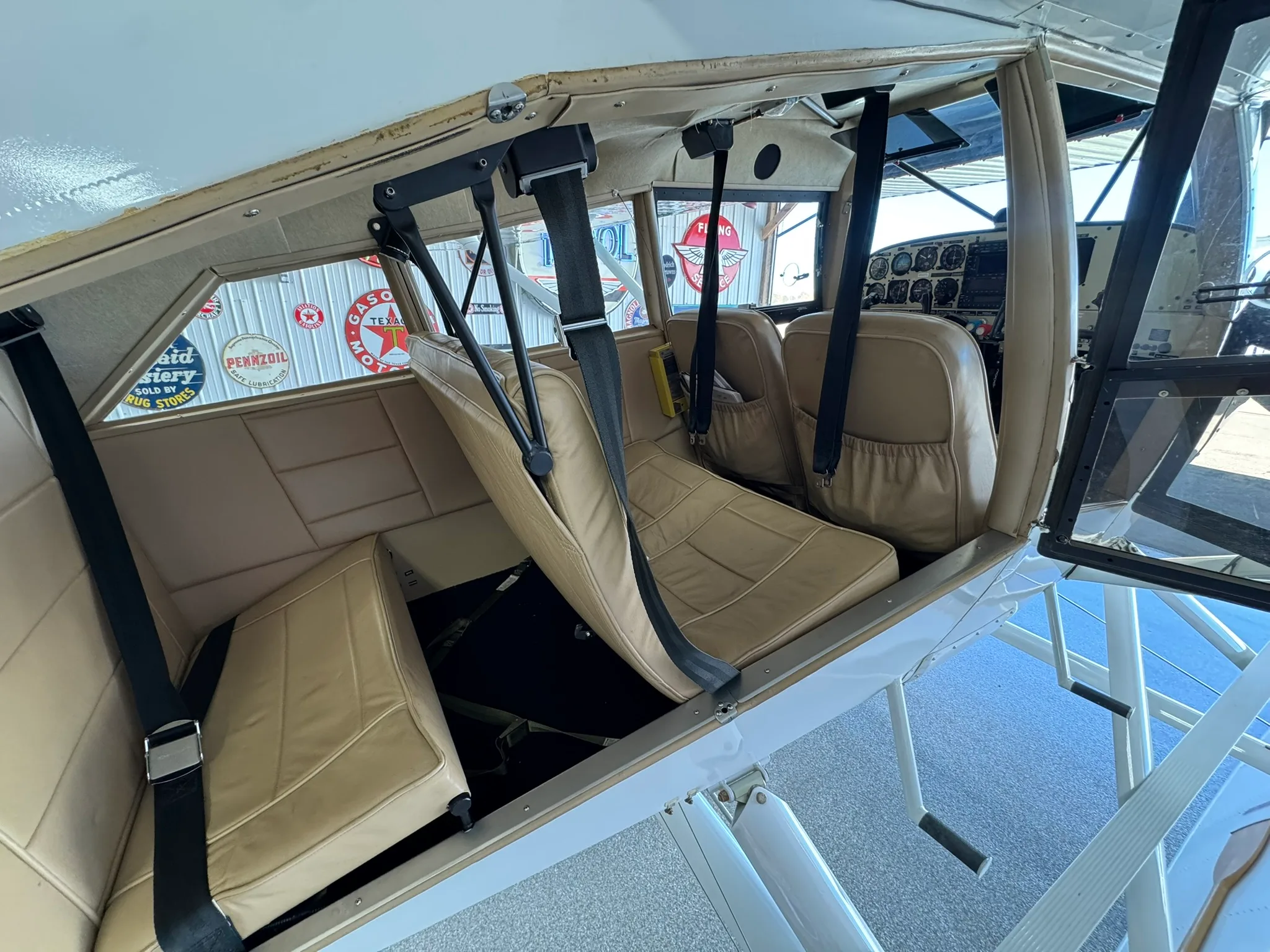 View of the tan leather seats in the aircraft cabin.