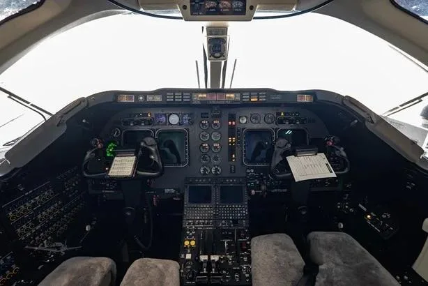 The cockpit of the aircraft, showing the instrument panel, yokes, and various controls.