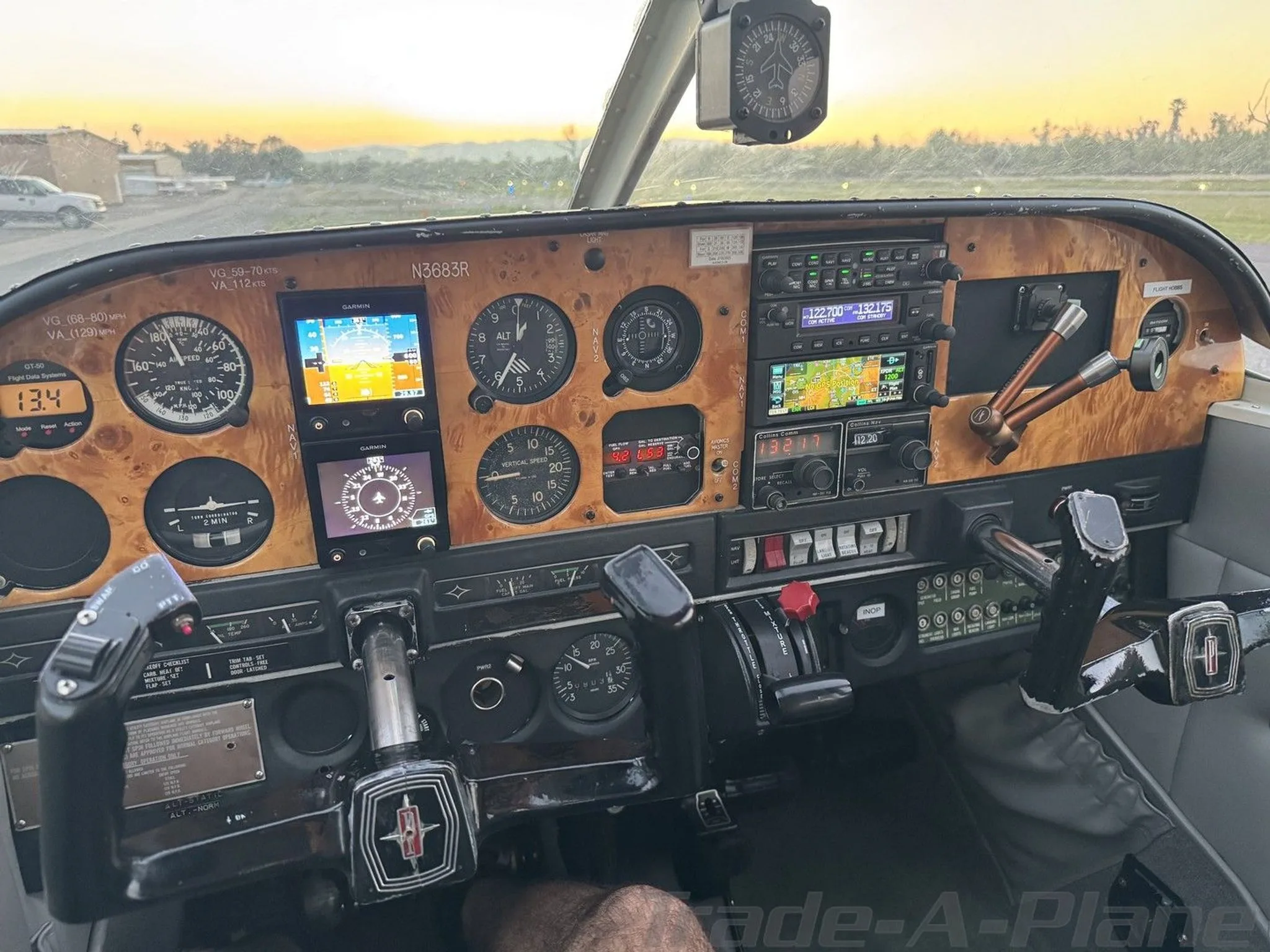 The cockpit of the N3683R aircraft, featuring a woodgrain instrument panel with modern Garmin displays and traditional gauges.