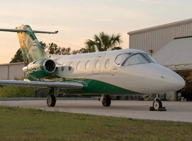 Beechcraft Premier 400A aircraft parked on the ground with a green and white paint scheme.