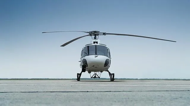 A white single-engine helicopter, registration B-7440, viewed head-on on an asphalt runway.