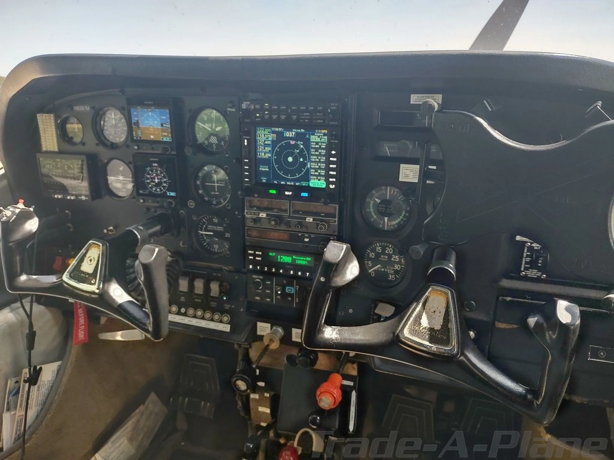 A wide view of a Cessna cockpit featuring a complex instrument panel with dual yokes and various avionics.
