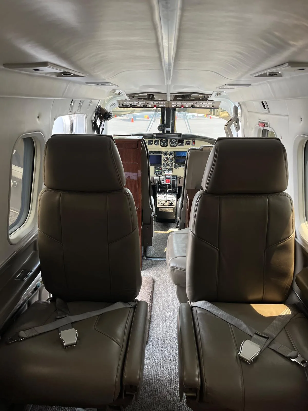 View of the aircraft's interior, showing the leather seats and cockpit.