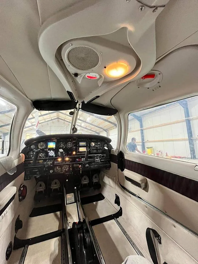 A view of the aircraft's cockpit, showing the instrument panel, controls, and overhead panel.