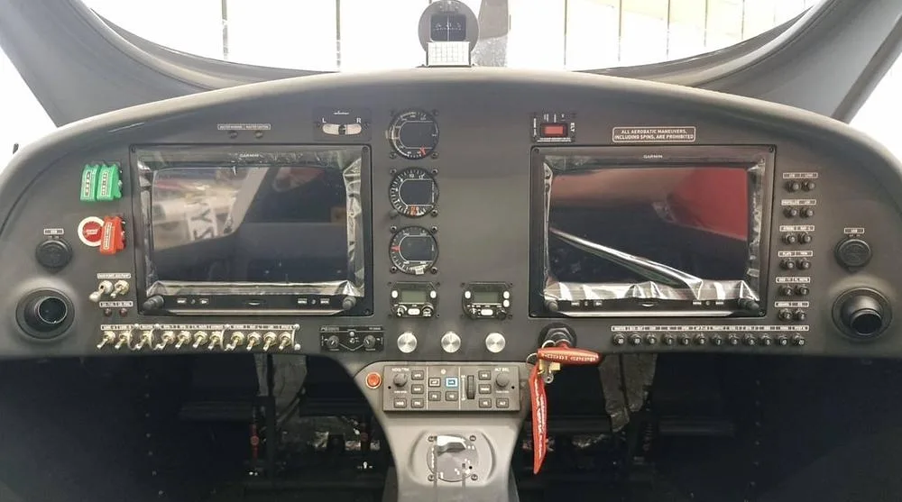 The cockpit of a light aircraft, showing two large Garmin displays and various instruments.