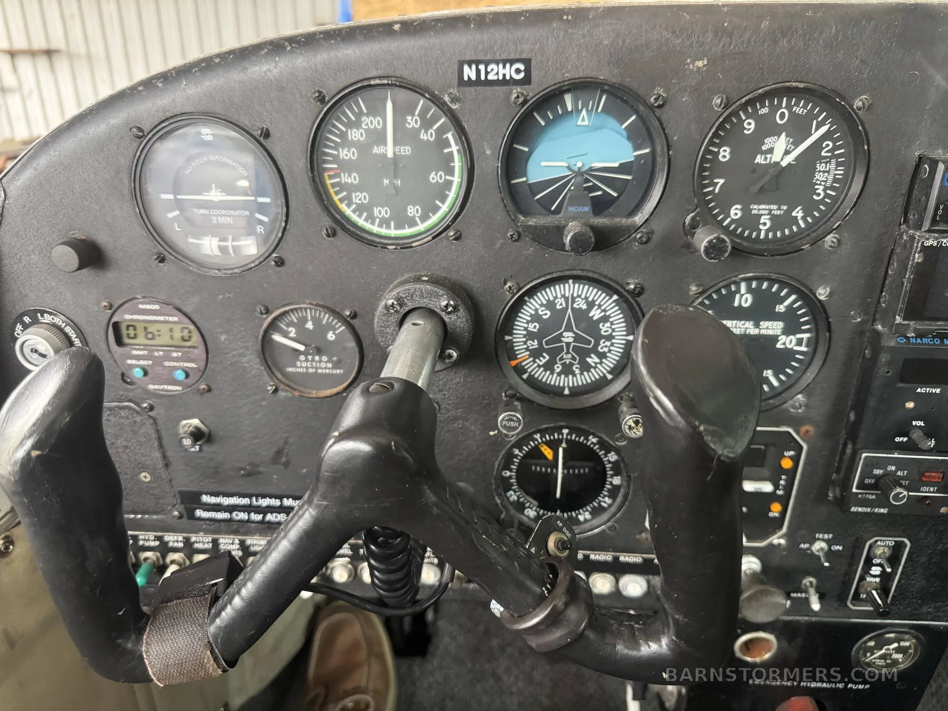 A close-up view of a vintage aircraft cockpit with analog gauges and a control yoke.