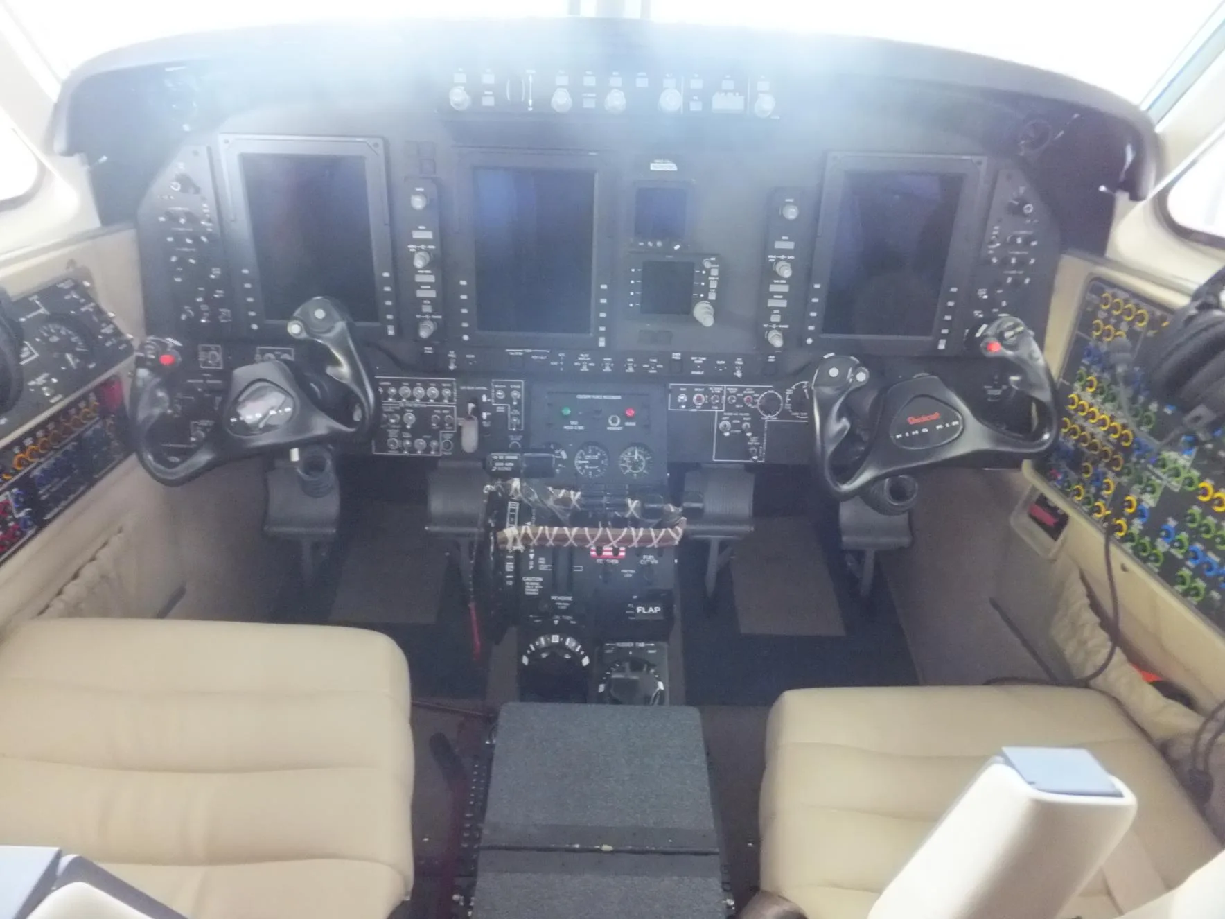 The cockpit of the King Air aircraft features dual control wheels and a modern glass panel display.