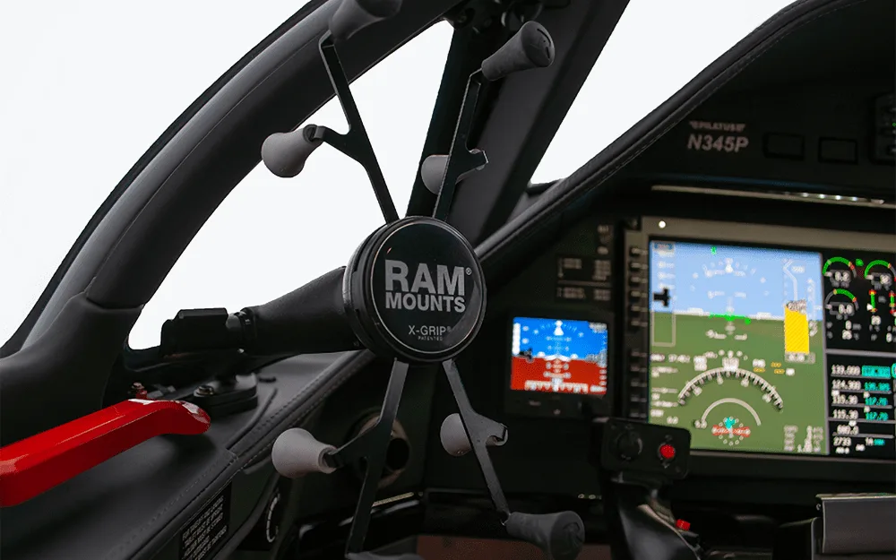A close-up view of a RAM Mounts phone holder attached to the control yoke in the Pilatus PC-12 NGX cockpit.
