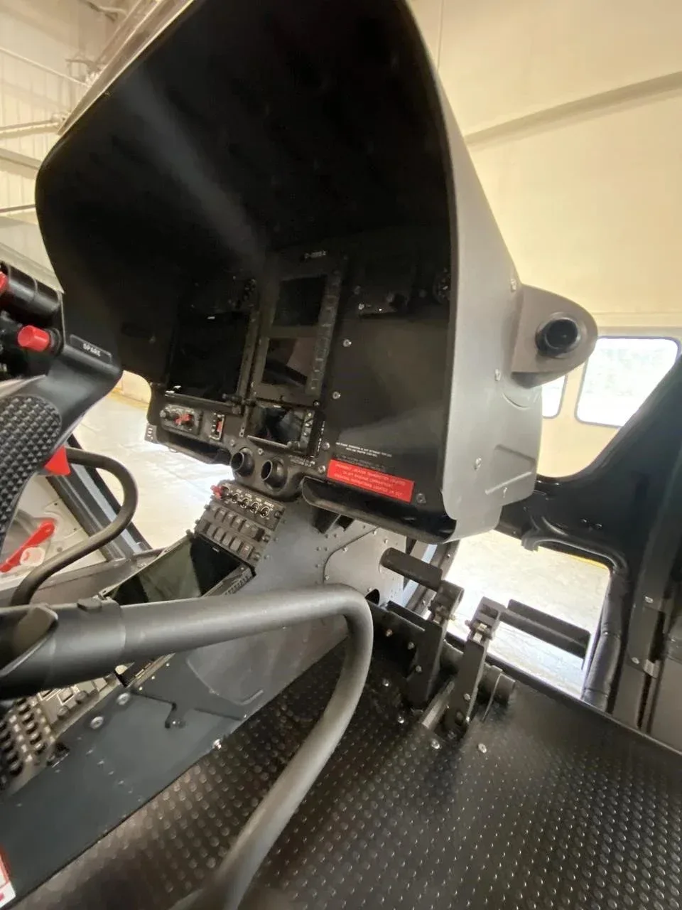 An interior view of the helicopter's cockpit, showing the instrument panel and flight controls.