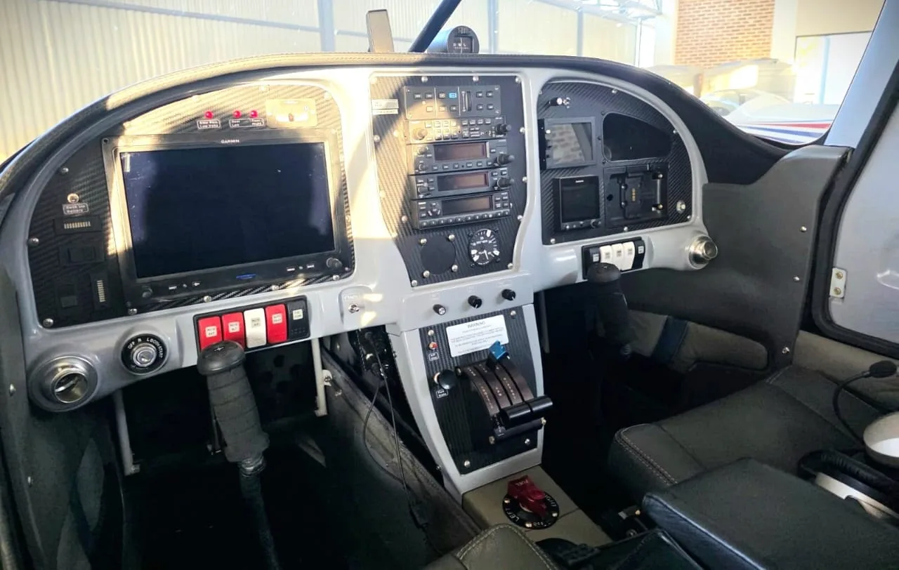 The cockpit of a Van's RV-10 aircraft, showing the instrument panel with screens and controls.