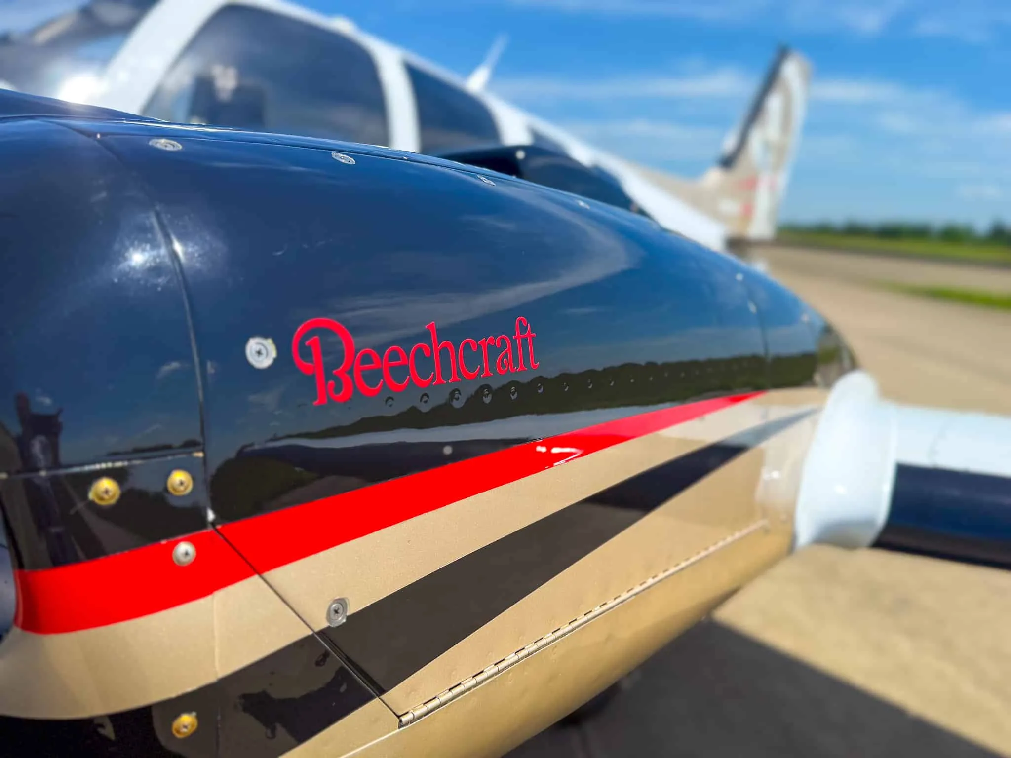 Close-up of the black and gold engine cowling with 'Beechcraft' in red script.