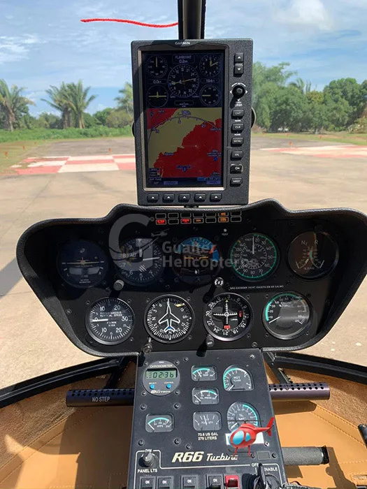 The cockpit of a Robinson R66 Turbine helicopter, showing the instrument panel, controls, and a Garmin GPS display.