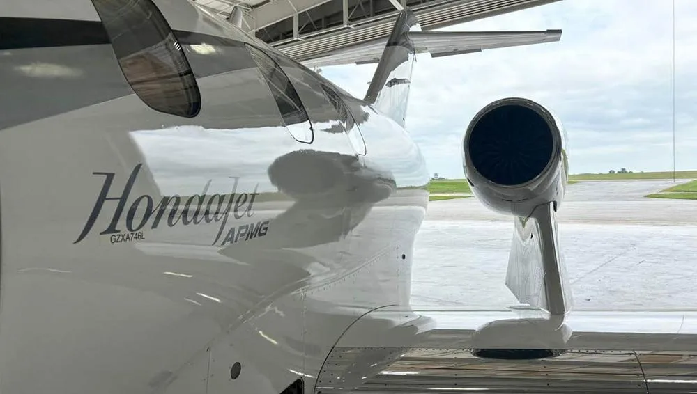 A close-up view of the white HondaJet fuselage and engine, showing the "Hondajet" logo.