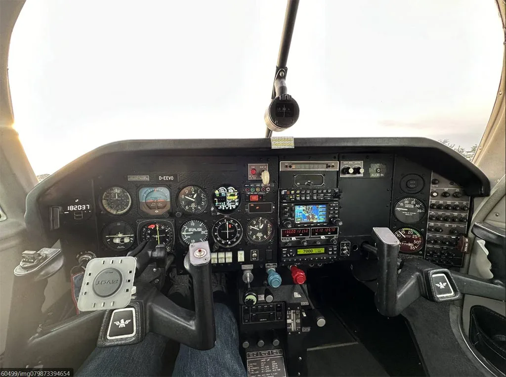 A wide view of the Mooney M20J cockpit, showing the instrument panel, yokes, and avionics.