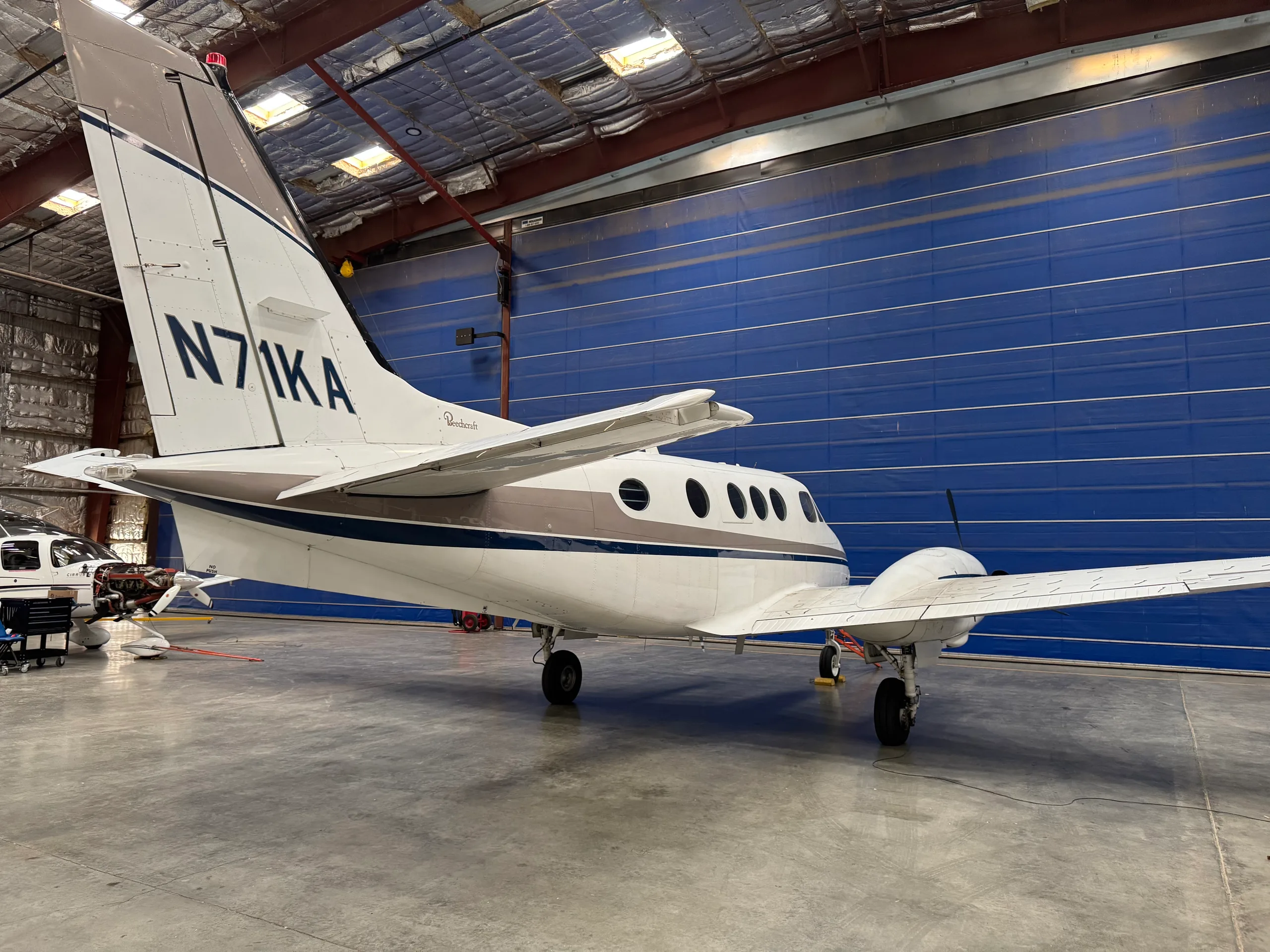 Rear view of N71KA King Air turboprop aircraft parked in a hangar.
