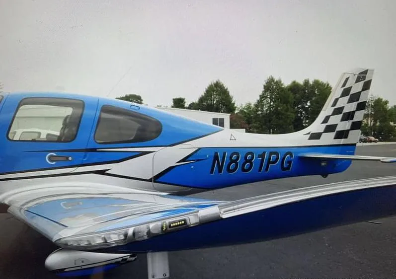 A close-up view of the tail and rear fuselage of a blue and silver Cirrus SR22 aircraft with N881PG registration.