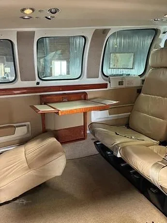 The tan leather interior of a Beechcraft Baron 58 cabin, showing passenger seats and a fold-out table.
