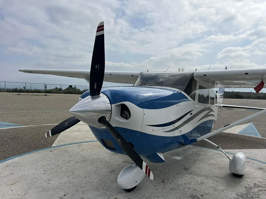 Front view of a white and blue Cessna Stationair TC (N1330G) showing the propeller and nose.