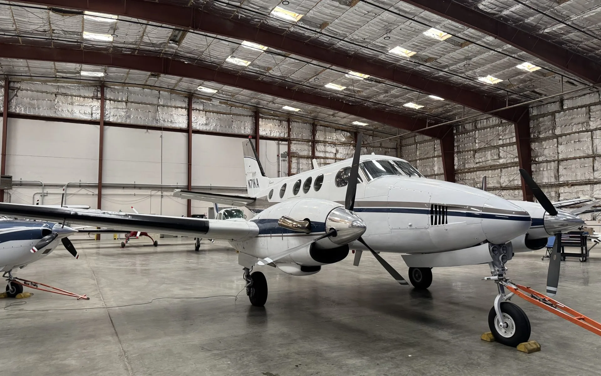 Front view of N71KA King Air turboprop aircraft parked in a hangar.